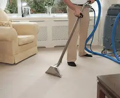 Carpet cleaning professional removing dirt and stains with a hot-water extraction tool in a home, Boston, MA.